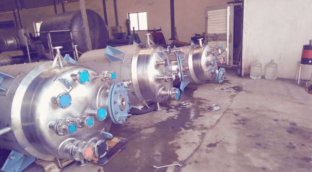 Row of process vessels with nozzles and fittings in a workshop