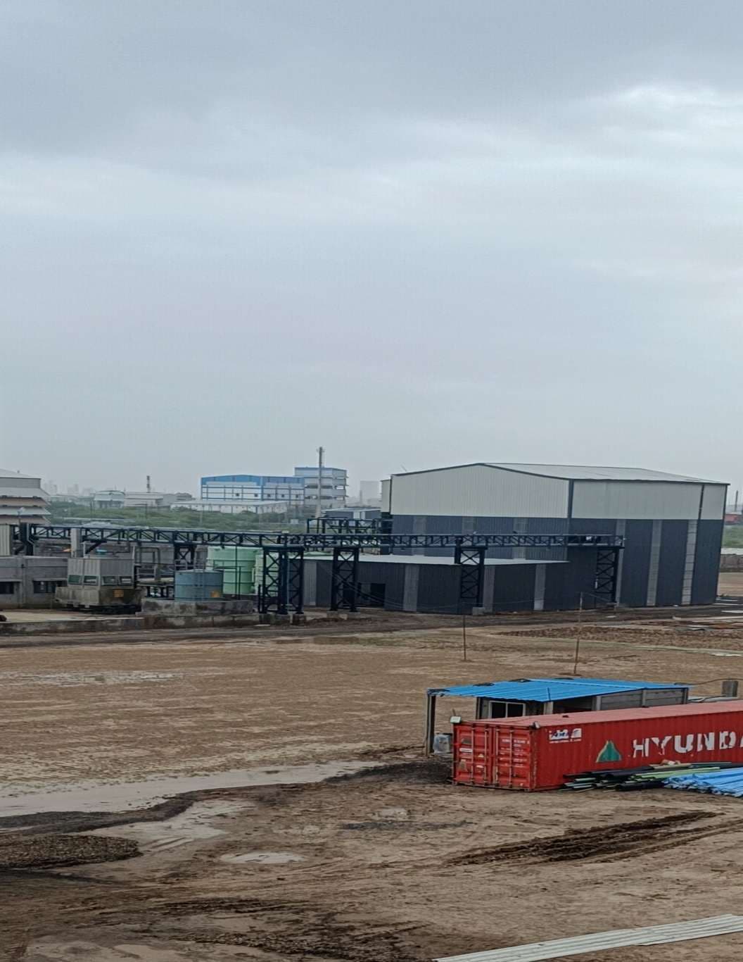 Industrial shed with metal roofing, wall sheeting and an adjoining pipe rack